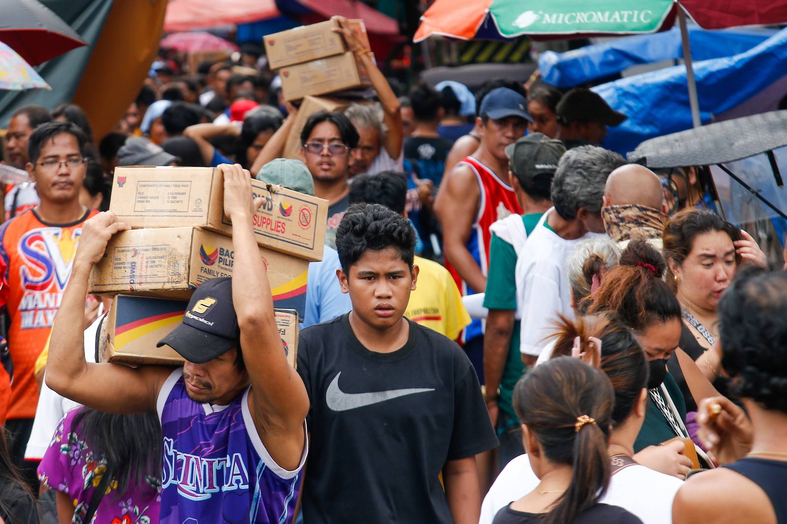 Residents of Happyland in Tondo, Manila, queue for Department of Social Welfare and Development family food packs on Saturday morning. The community was struck by a fire on September 13 that escalated to Task Force Bravo.