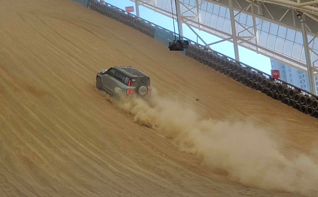 THE Yangwang U8 shows its extreme capability by climbing a steep indoor sand dune.