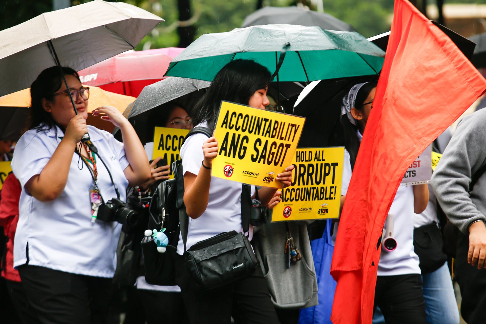 Students from the University of Santo Tomas walk out of their classes on Monday despite the rain brought by thunderstorms and habagat to protest the massive corruption in the government.