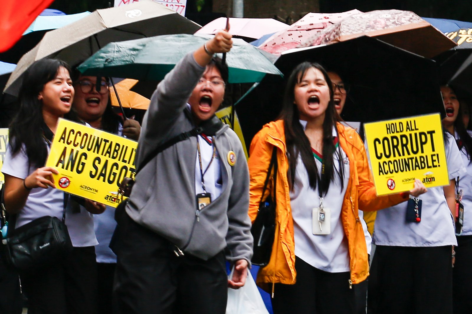 Students from the University of Santo Tomas walk out of their classes on Monday despite the rain brought by thunderstorms and habagat to protest the massive corruption in the government.