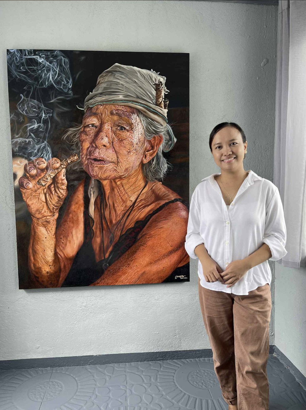 Sunshine Vitto with one of her works, ‘Mensahe Patungo sa Lumikha.’