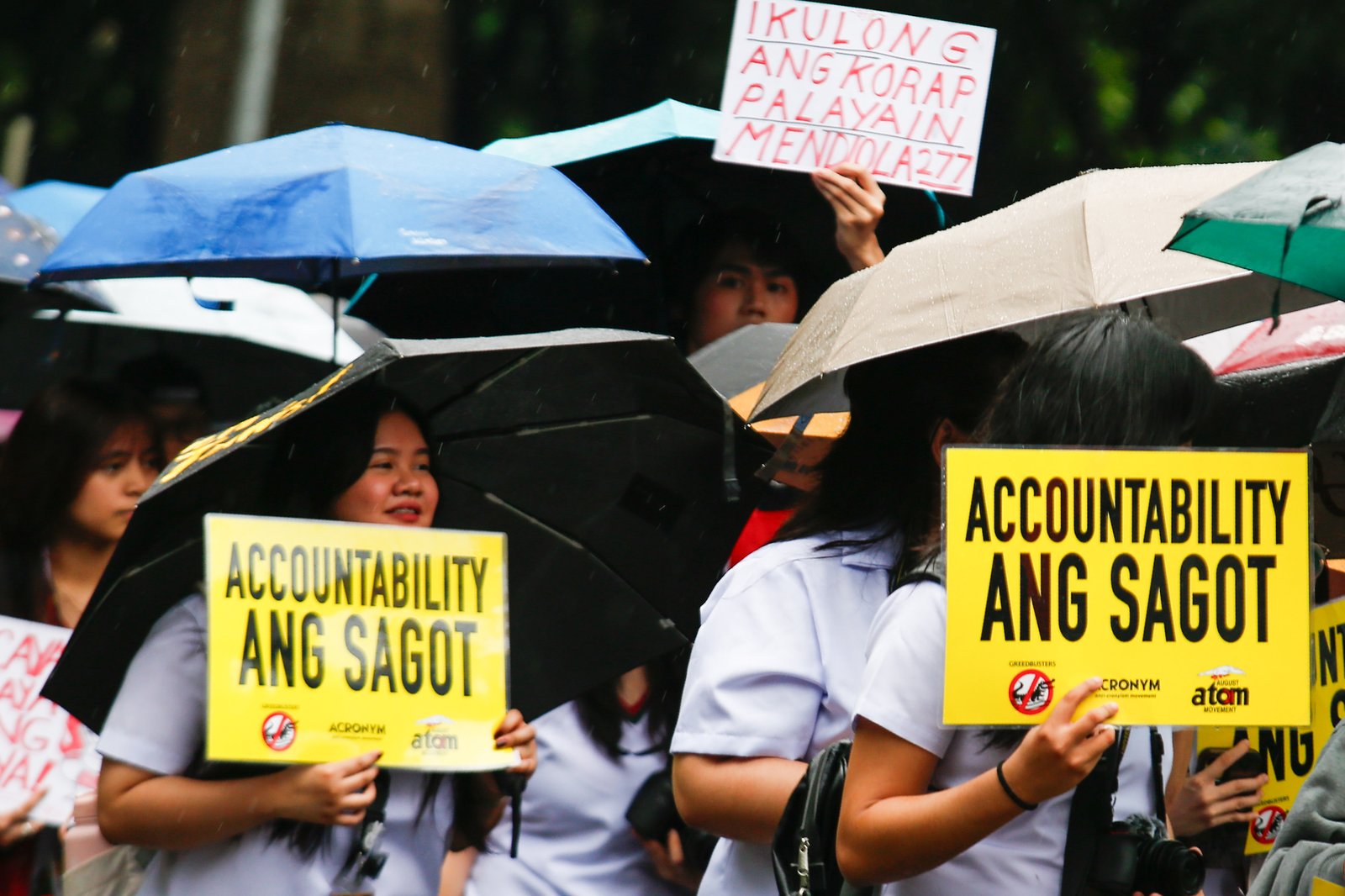 Students from the University of Santo Tomas walk out of their classes on Monday despite the rain brought by thunderstorms and habagat to protest the massive corruption in the government.