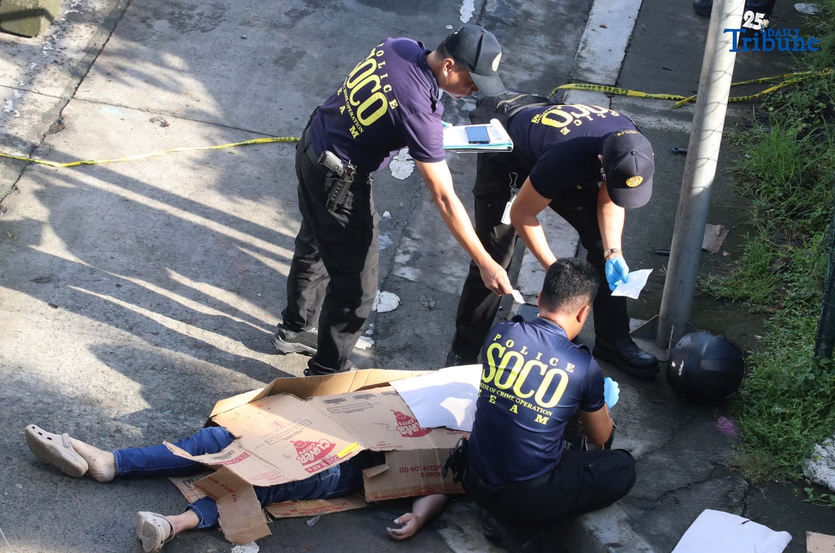 Scene of the Crime Operatives (QCPD-SOCO) examine the body of a man allegedly gunned down by motorcycle-riding assailants along Katipunan Avenue, Barangay Loyola Heights, Quezon City.
