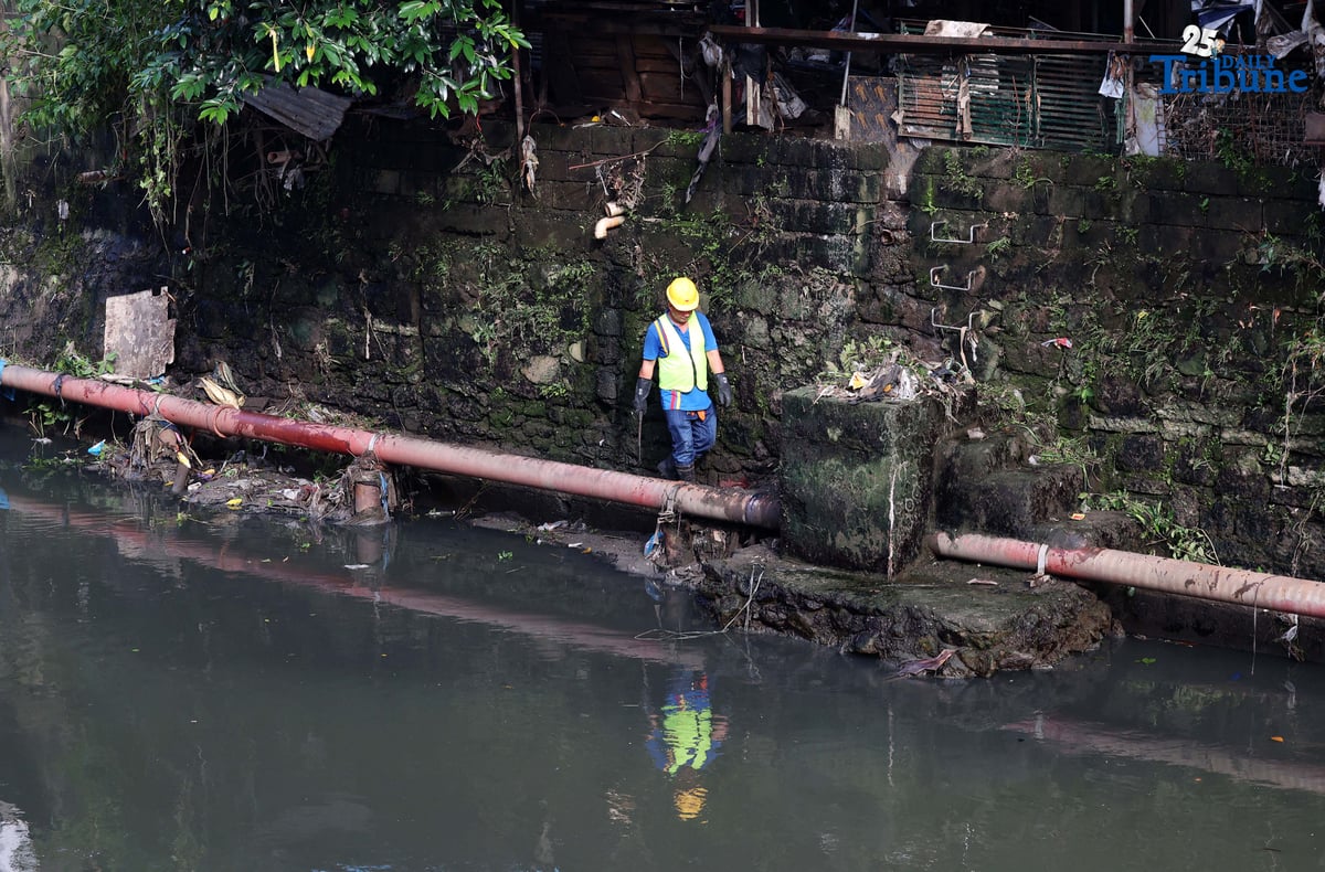 MMDA personnel clear garbage and debris along Lagarian Creek in Barangay Kalusugan on Thursday, October 2, 2025, as part of President Ferdinand Marcos Jr.’s Bayanihan sa Estero program, which seeks to ease flooding by declogging waterways.