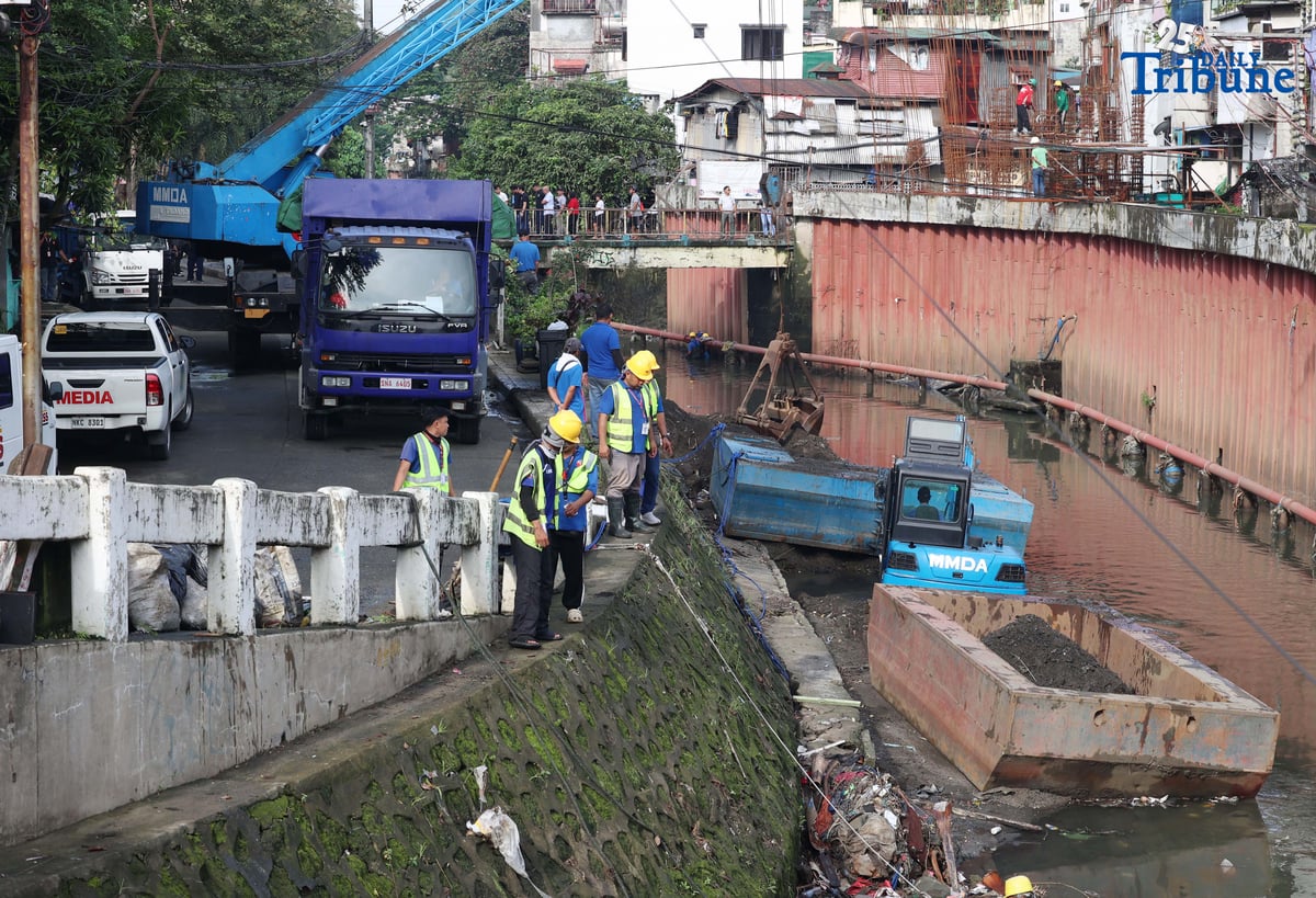 MMDA personnel clear garbage and debris along Lagarian Creek in Barangay Kalusugan on Thursday, October 2, 2025, as part of President Ferdinand Marcos Jr.’s Bayanihan sa Estero program, which seeks to ease flooding by declogging waterways.