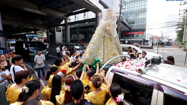 Devotees welcome the image of the La Naval with prayers during the parade of the holy image at churches within District 3 and 4 of Quezon City on Saturday, 11 October 2025.