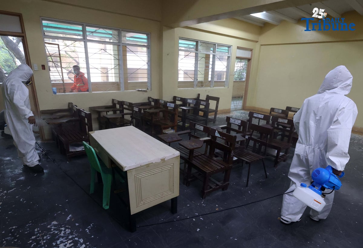 (October 14 2025) On Tuesday October 14 2025, volunteer Parent Teacher Association PTA, faculty members wearing personal protective equipment and conducting disinfection of the classrooms and common areas by using a water based solution, at Quezon City High School. Photo/Analy Labor