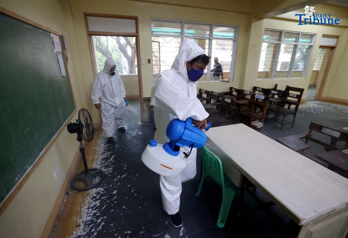 (October 14 2025) On Tuesday October 14 2025, volunteer Parent Teacher Association PTA, faculty members wearing personal protective equipment and conducting disinfection of the classrooms and common areas by using a water based solution, at Quezon City High School. Photo/Analy Labor