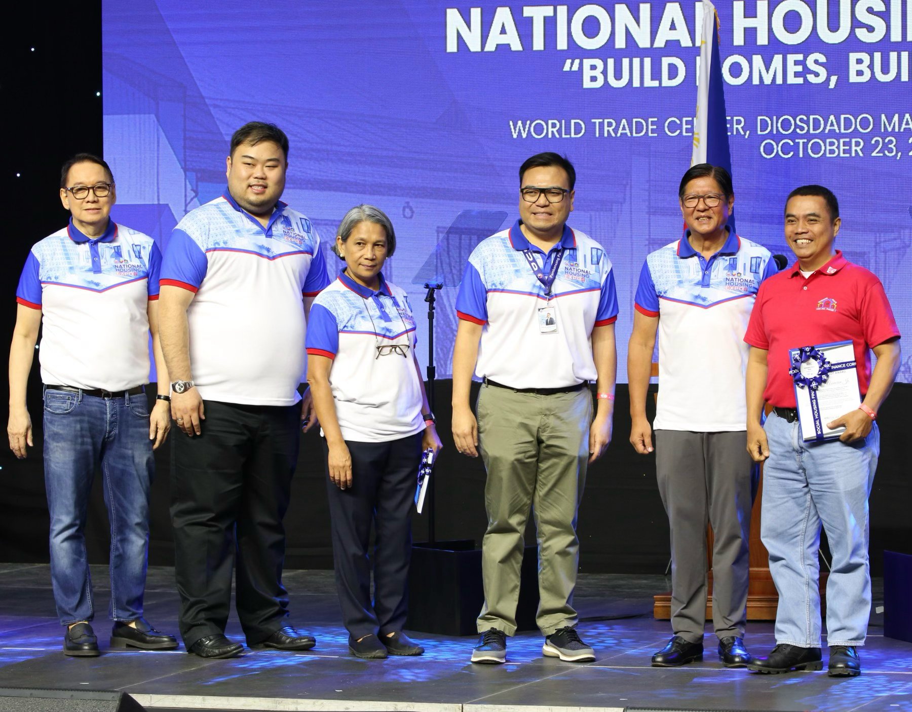 Joining President Ferdinand R. Marcos Jr. (second from right) in the ceremonial awarding of Certificates of Lot Award to beneficiaries of the Social Housing Finance Corporation’s Enhanced Community Mortgage Program during the National Housing Expo at the World Trade Center in Pasay City on Thursday, 23 October are Department of Human Settlements and Urban Development Secretary Jose Ramon Aliling (third from right), SHFC president and CEO Federico Laxa (left), NHA general manager Joeben Tai and Pag-IBIG Fund CEO Marilene Acosta.