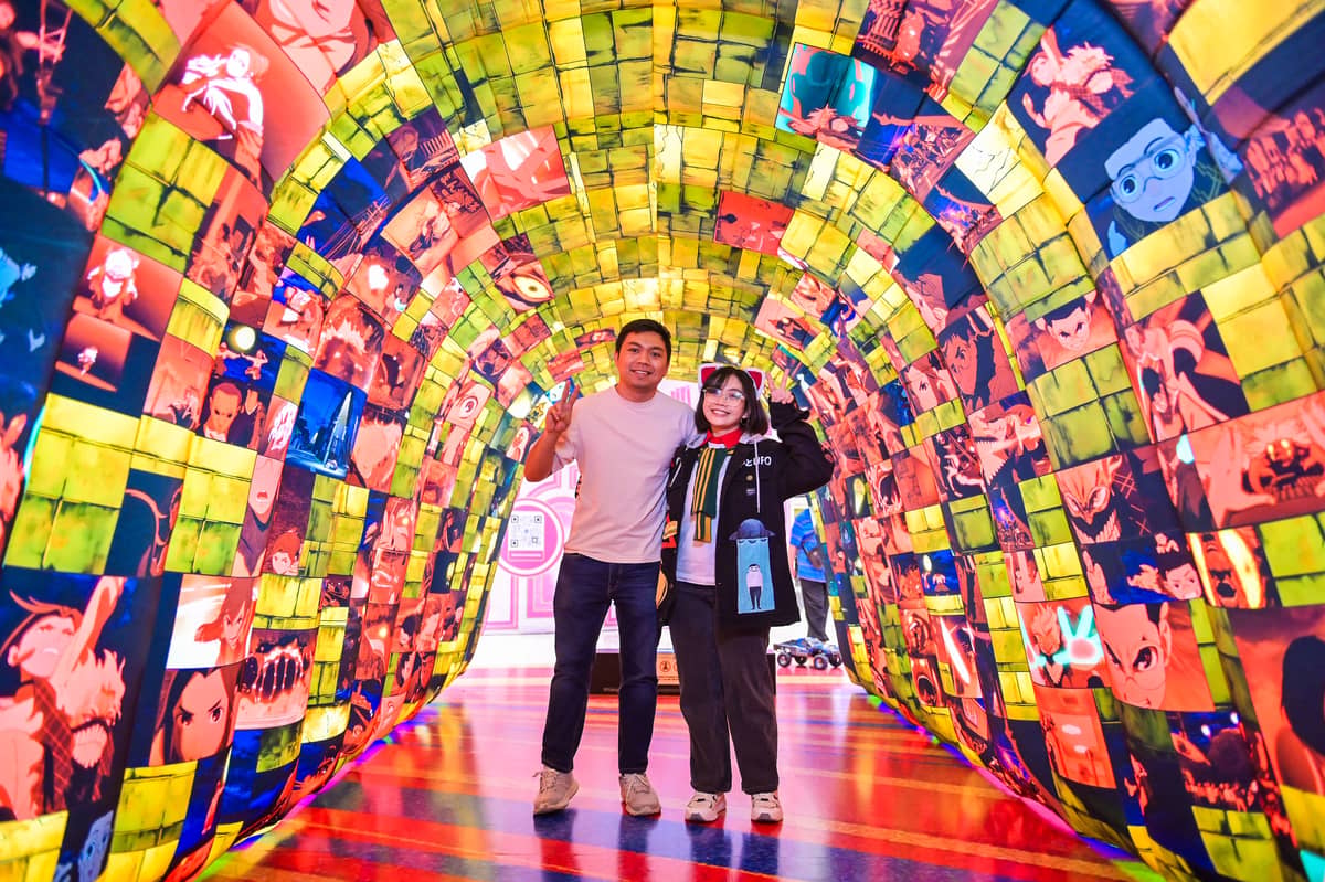 Fans snap a photo at the ‘Dan Da Dan’ tunnel inflatable, one of the immersive displays of the activation.