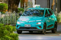 A GREEN GSM electric taxi cruises through the city, showing how clean transport is becoming part of daily life.