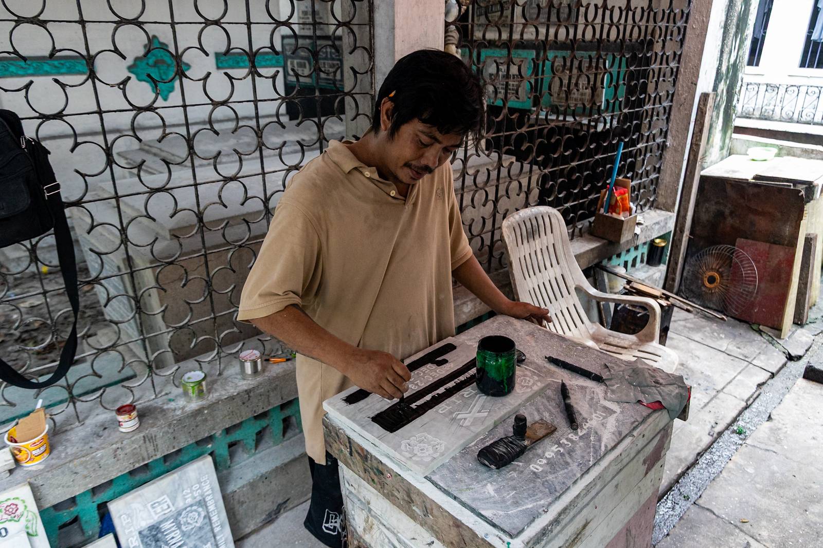Tombstone maker Socsoc Gamurot engraves and paints names on a marble slab at his makeshift workshop inside the Manila North Cemetery as the annual observance of All Saints’ Day approaches.

 he 40-year-old, who resides inside the country’s largest cemetery, shares that each tombstone costs ₱1,200 and that he crafts an average of 10 pieces a day.