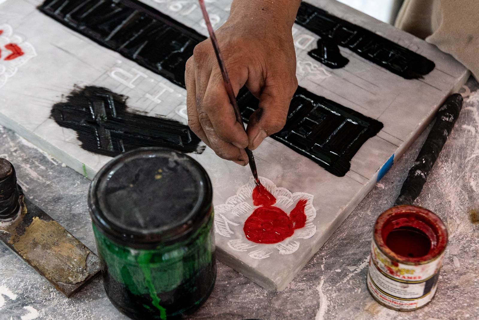 Tombstone maker Socsoc Gamurot engraves and paints names on a marble slab at his makeshift workshop inside the Manila North Cemetery as the annual observance of All Saints’ Day approaches.

 he 40-year-old, who resides inside the country’s largest cemetery, shares that each tombstone costs ₱1,200 and that he crafts an average of 10 pieces a day.