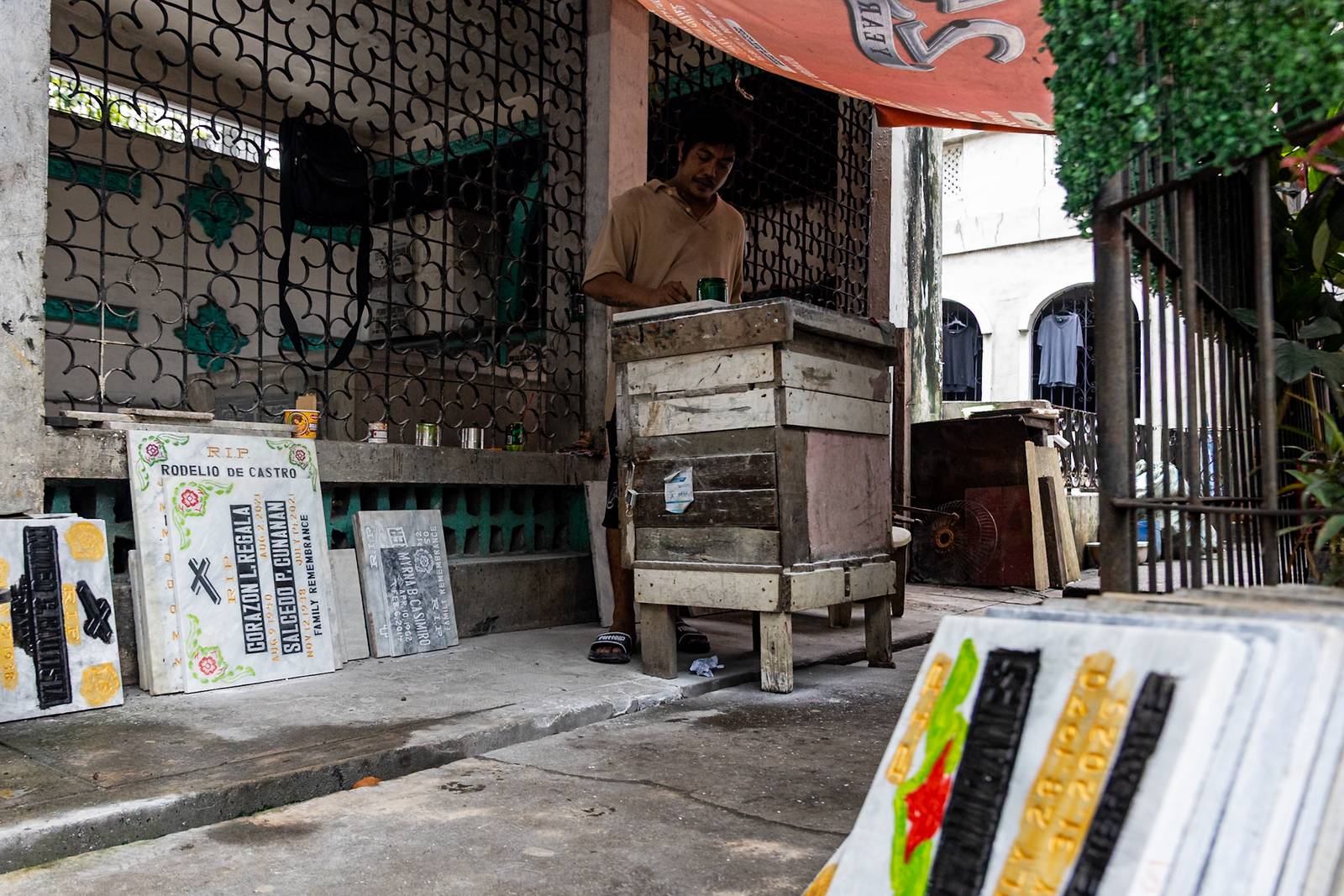 Tombstone maker Socsoc Gamurot engraves and paints names on a marble slab at his makeshift workshop inside the Manila North Cemetery as the annual observance of All Saints’ Day approaches.

 he 40-year-old, who resides inside the country’s largest cemetery, shares that each tombstone costs ₱1,200 and that he crafts an average of 10 pieces a day.