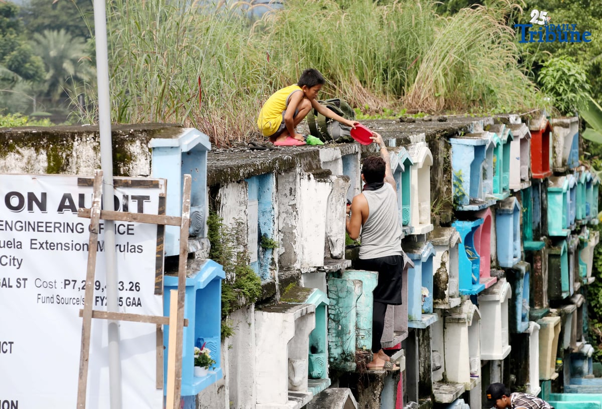 (October 31 2025) A few families were seen  visit their departed loved ones  to offer flowers and candles at Valenzuela public cemetery, karuhatan Valenzuela City on Friday October 31 2025, ahead of all Souls Day celebration. Photo/Analy Labor