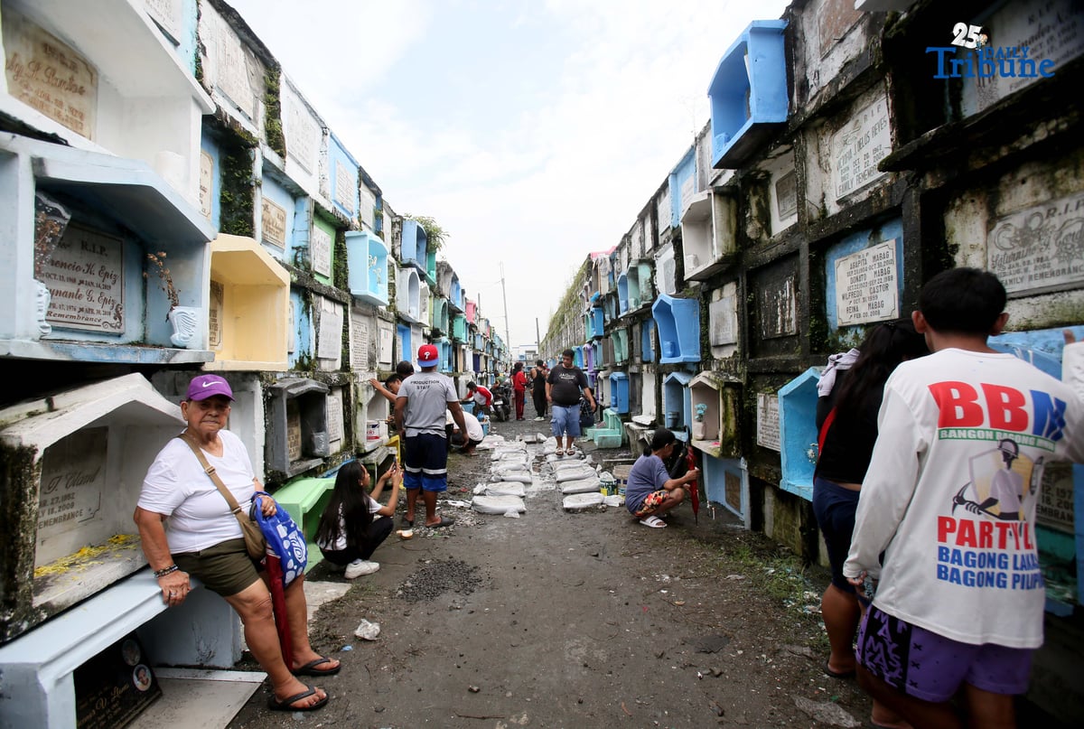 (October 31 2025) A few families were seen  visit their departed loved ones  to offer flowers and candles at Valenzuela public cemetery, karuhatan Valenzuela City on Friday October 31 2025, ahead of all Souls Day celebration. Photo/Analy Labor