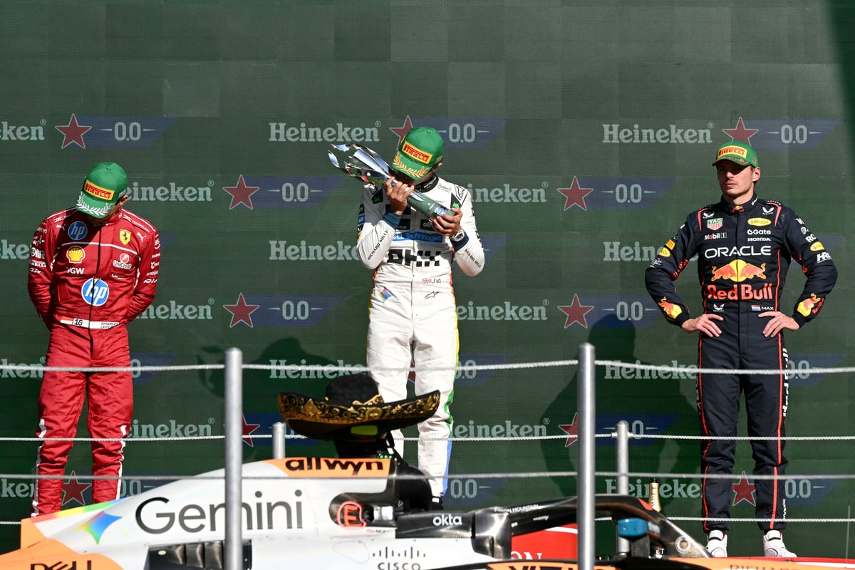 Triumphant McLaren driver Lando Norris kisses the winner’s trophy on the podium beside Ferrari’s Charles Leclerc and Red Bull’s Max Verstappen after clinching victory at the Mexico City Grand Prix.