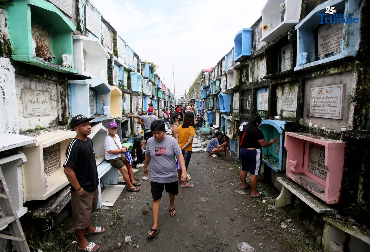(October 31 2025) A few families were seen  visit their departed loved ones  to offer flowers and candles at Valenzuela public cemetery, karuhatan Valenzuela City on Friday October 31 2025, ahead of all Souls Day celebration. Photo/Analy Labor
