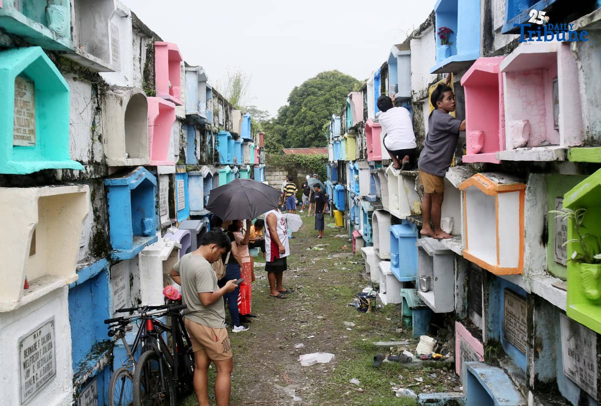 (October 31 2025) A few families were seen visit their departed loved ones to offer flowers and candles at Valenzuela public cemetery, karuhatan Valenzuela City on Friday October 31 2025, ahead of all Souls Day celebration. Photo/Analy Labor