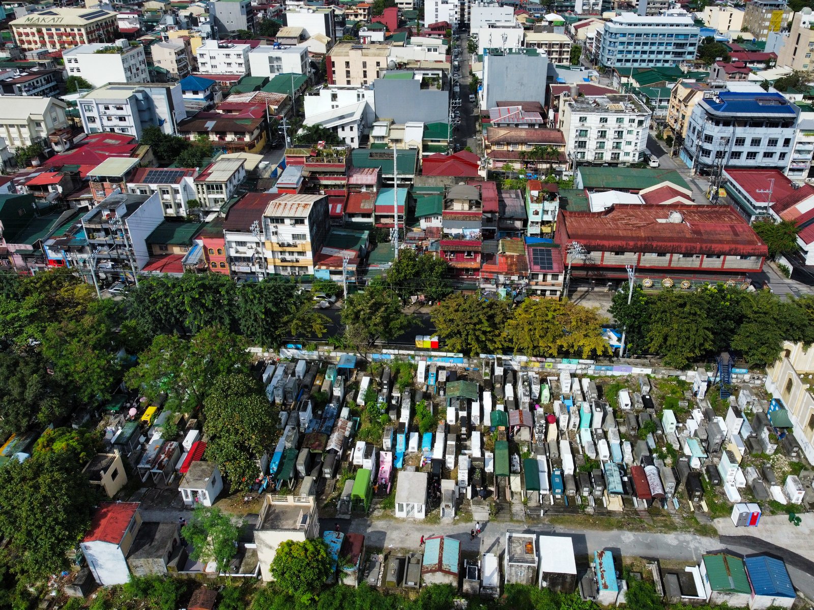 The vast greenery of Manila South Cemetery stands in contrast with the modern tall buildings of Makati City in this photo taken on All Saints' Day. As of 1:00 in the afternoon, at least 46,000 people have visited the Manila South Cemetery.