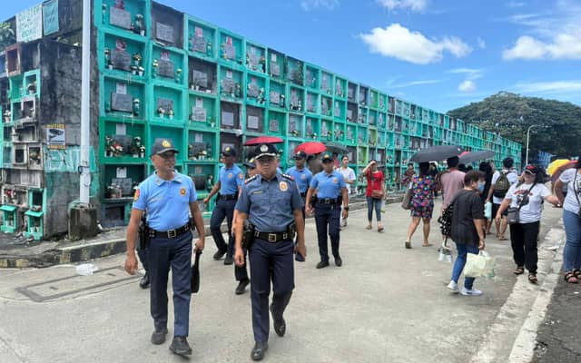 Officers from the Quezon City Police District inspect the Novaliches Public Cemetery in Novaliches Proper, Quezon City in observance of Oplan ‘Ligtas Undas’ on Sunday.