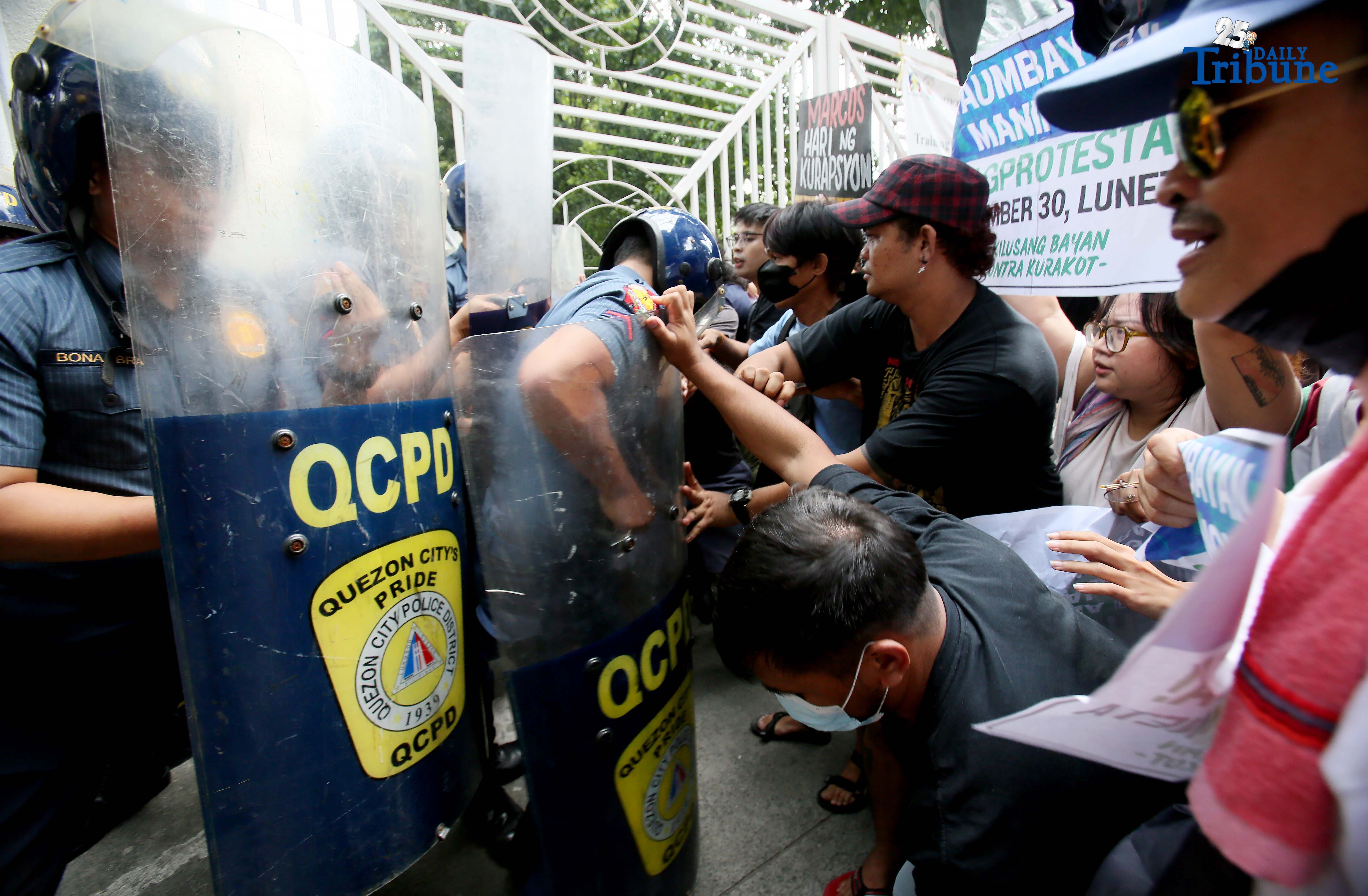 Tension erupts outside the Office of the Ombudsman in Quezon City as protesters clash with QCPD anti-riot police during a rally denouncing “selective justice.” The groups demanded Ombudsman Jesus Crispin Remulla hold all officials allegedly linked to anomalous flood control projects accountable.