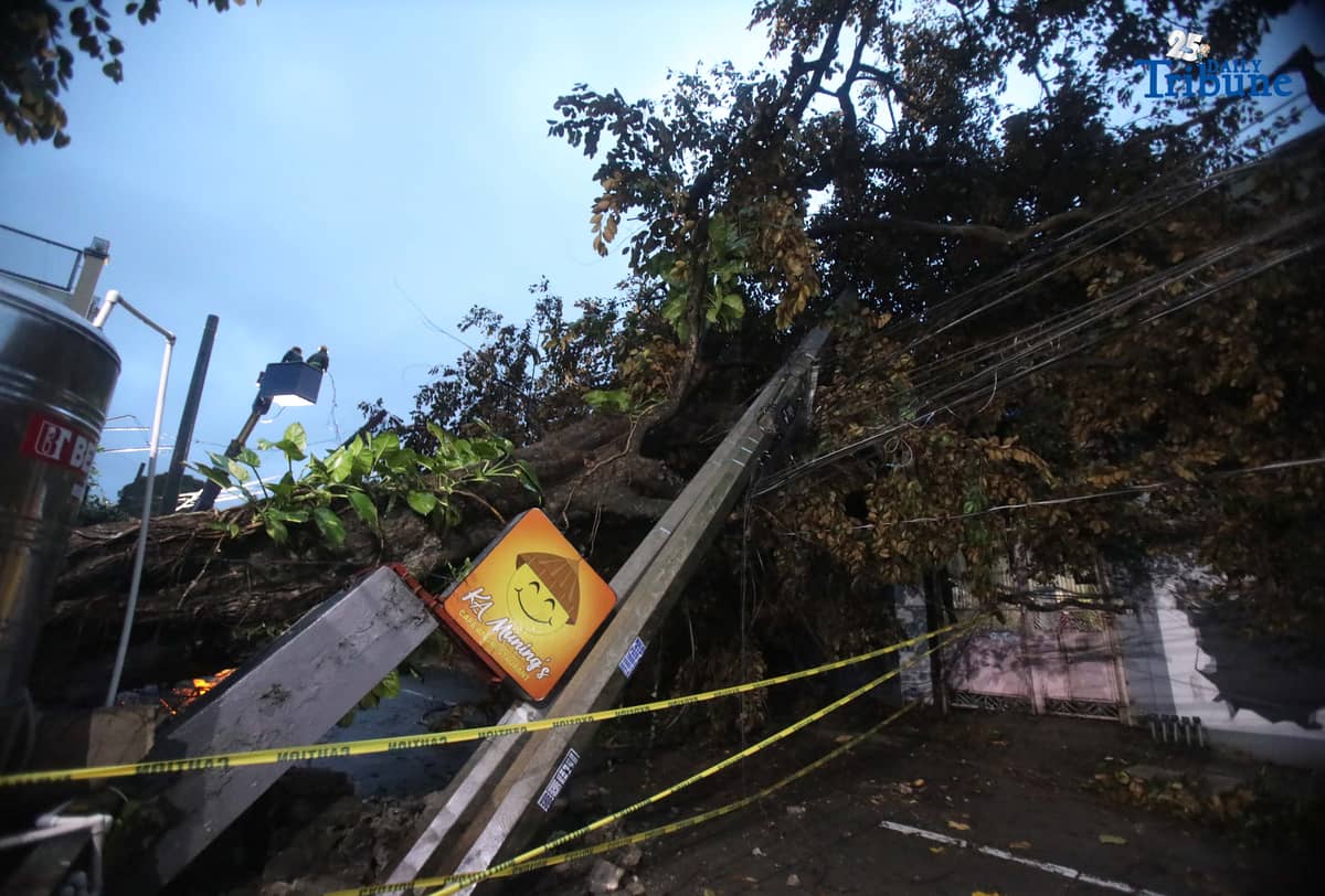 ELCOR, a Meralco contractor, responds to a toppled electric post along K-1st Street in Quezon City early Monday, after strong winds from Super Typhoon Uwan caused a tree to fall and damage the line.
