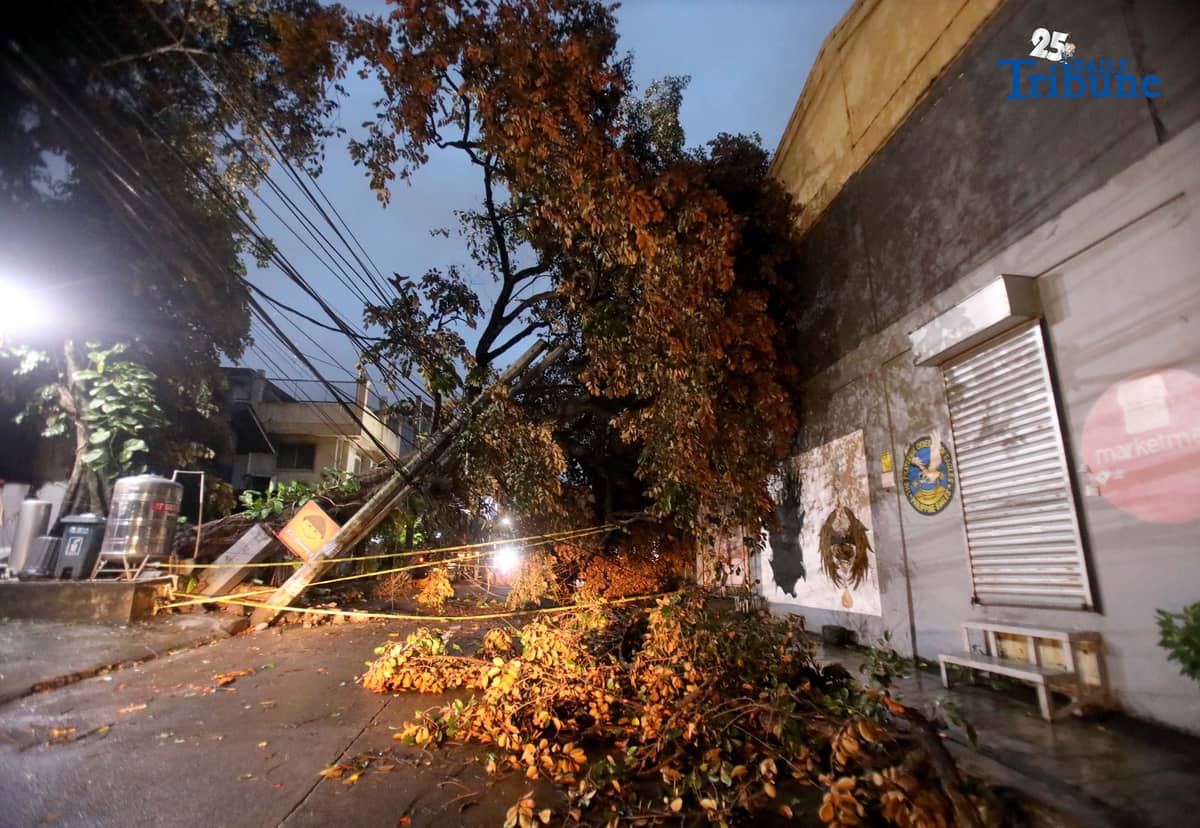 ELCOR, a Meralco contractor, responds to a toppled electric post along K-1st Street in Quezon City early Monday, after strong winds from Super Typhoon Uwan caused a tree to fall and damage the line.