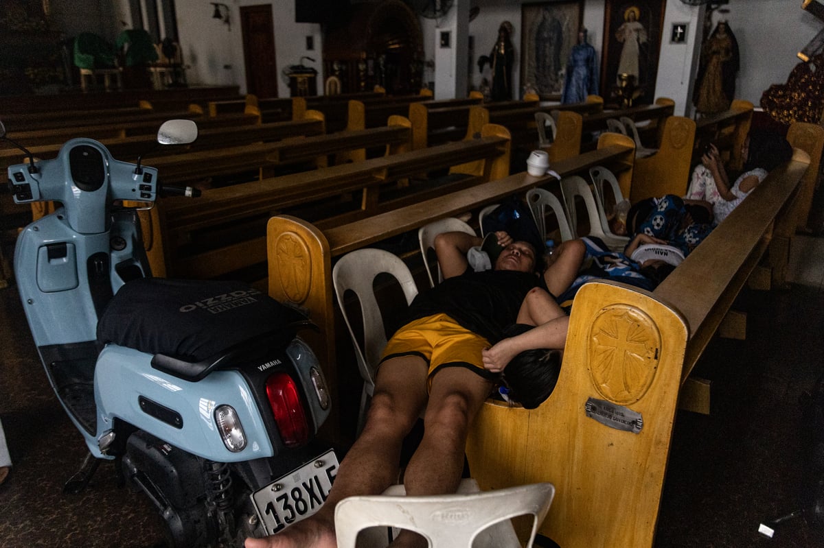 People wade through chest-deep floodwater in Barangay Navotas East, Navotas City on Monday, 10 November 2025, after the Malabon-Navotas Navigational Gate overflowed Sunday night amid high tide and storm surges driven by Super Typhoon Uwan.