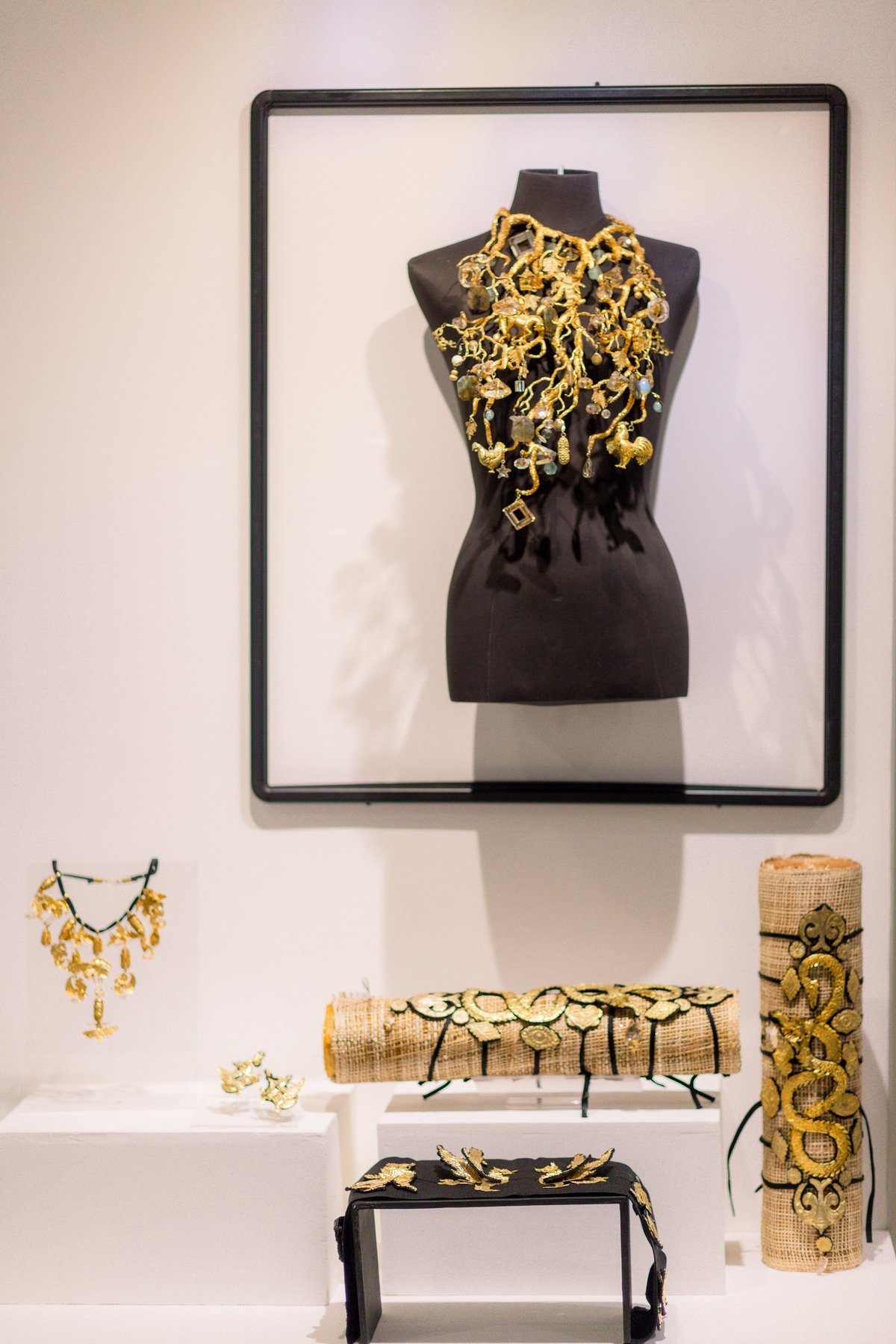 Collar breastplate depicting coral, and embellished shin guards, necklace, and earrings.
