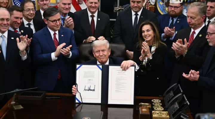 US President Donald Trump (C) shows the signed bill to re-open the federal government in the Oval Office of the White House