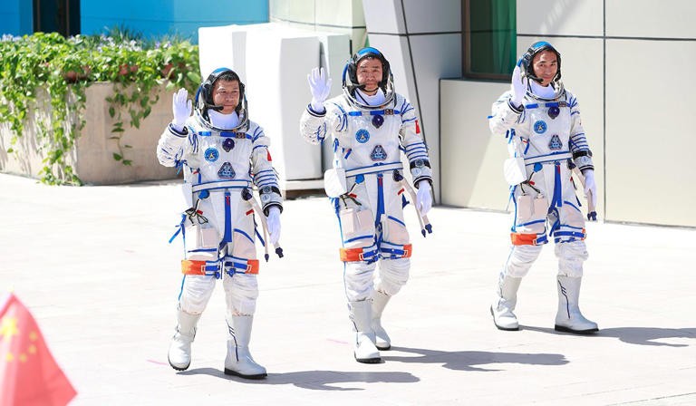 3 astronauts defy space peril 
aboard debris-damaged craft