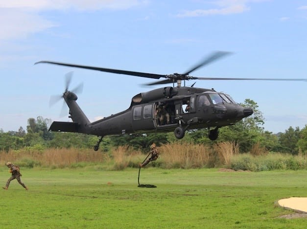 Philippine Special Operations Forces execute a fast-rope descent from a Black Hawk helicopter during a tactical exercise.