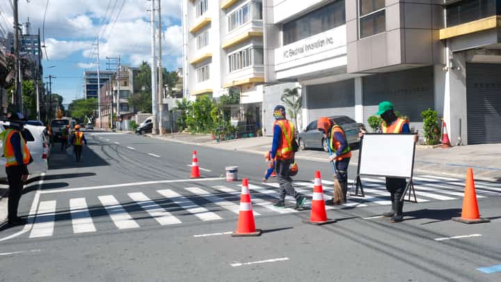 Workers from the Department of Public Works and Highways repaint a pedestrian crossing along Quezon Avenue. Various concerned agencies are already gearing up to enhance pedestrian safety along major thoroughfares in the metro.
