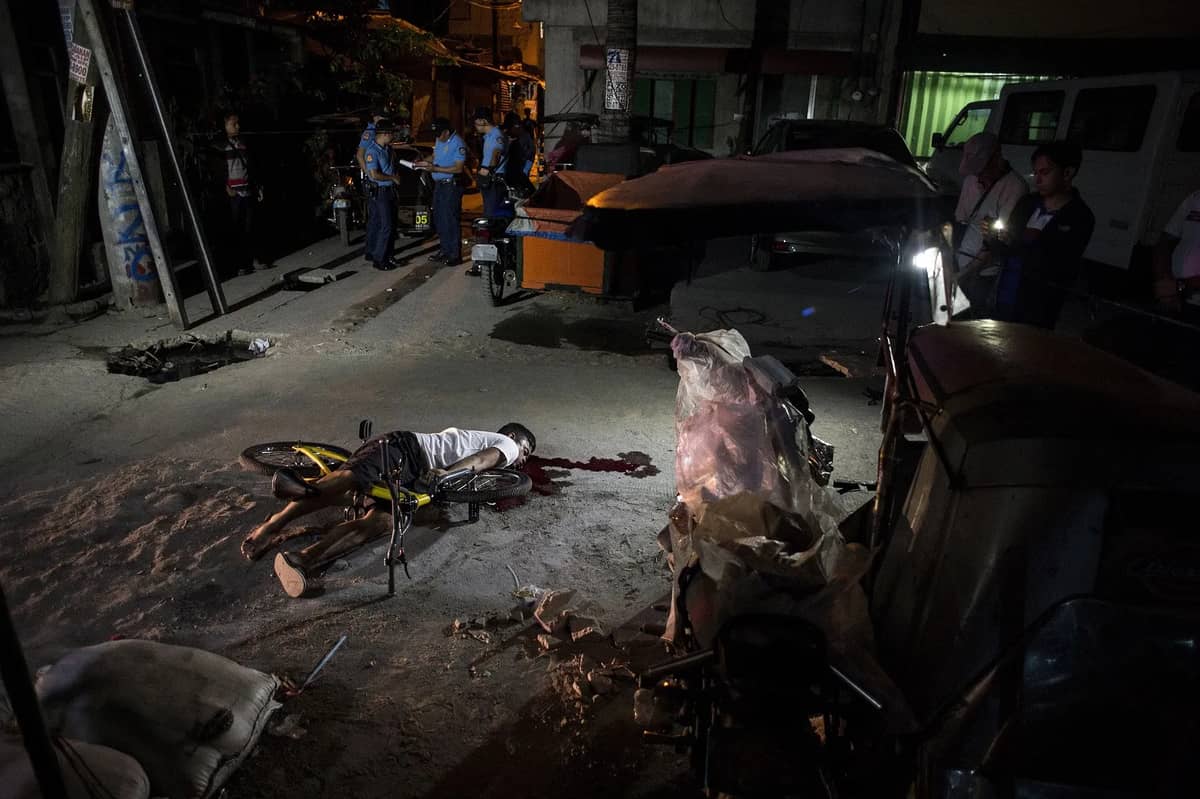 The body of an alleged drug dealer lies on the ground after he was killed by an unidentified assailant in Manila on 23 March 2018.