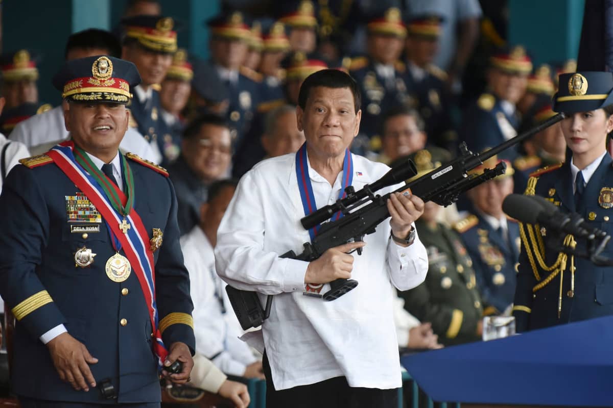 Philippine President Rodrigo Duterte holds a rifle next to outgoing Philippine National Police Chief Ronald Bato Dela Rosa in April.