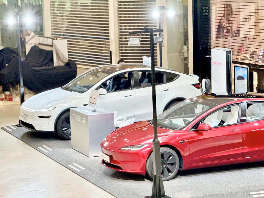SHOWCASE layout highlights the Model Y, the new Model 3, and a demo charging unit.