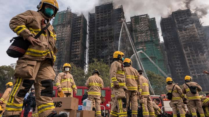 (FILE) Firemen get ready after a major fire swept through several apartment blocks at the Wang Fuk Court residential estate in Hong Kong's Tai Po district on November 27, 2025. Hong Kong firefighters were scouring a still-burning apartment complex for hundreds of missing people on November 27, a day after the blaze tore through the high-rises, killing at least 44.