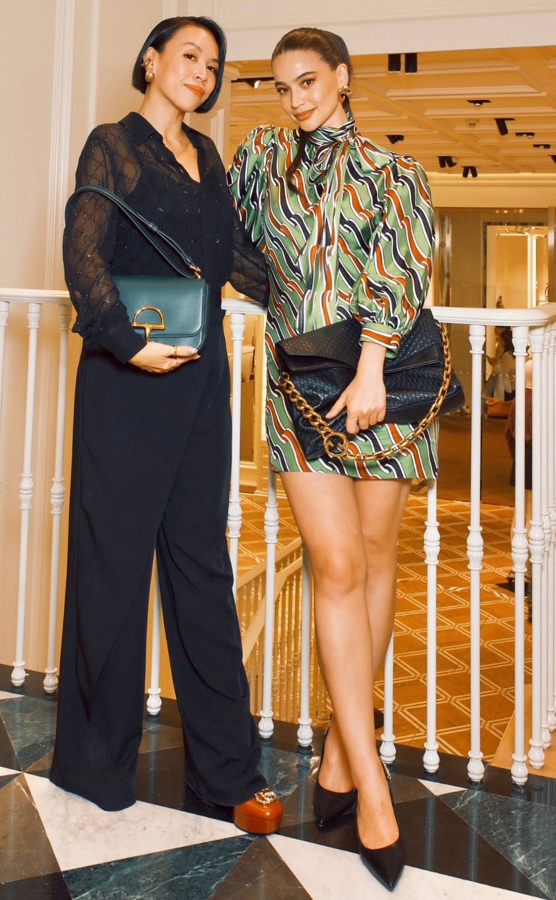 Communications manager of Gucci Philippines and Guam Andee Que and Anne Curtis-Smith wore a Gucci Cruise 2026 printed silk twill dress, Gucci large shoulder bag with chain, carp-shaped earrings, and women’s Gucci Signoria slingback pump