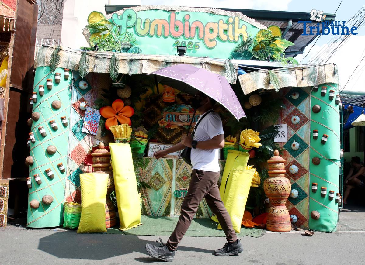 (December 01 2025) Pedestrians walk past houses decorated with colourful reusable materials as part of the 2025 SumBingTik (Suman, Bibingka, Latik) Festival in Cainta, Rizal on Monday December 1 2025. The SumBingTik Festival is an annual cultural long-week festival held in Cainta, Rizal, along with the town's founding anniversary and the feast of Our Lady of Light which is celebrated on December 1, the patron saint of the town. The festival was first celebrated in 2014. Photo/Analy Labor