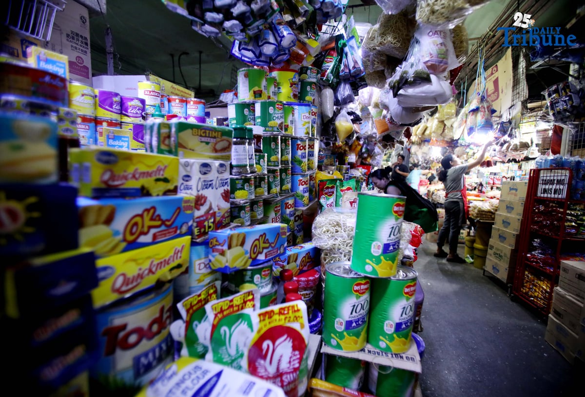 A market vendor assists shoppers buying Noche Buena ingredients at Commonwealth Market in Quezon City on Thursday, 4 December 2025. Vendors estimate that a complete Noche Buena set for a family of four now costs at least ₱800, even as Malacañang maintains that ₱500 is enough for a holiday meal, citing figures from the Department of Trade and Industry
