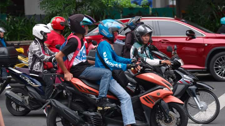 COMMUTERS hop on motorcycles from ride-hailing TNVS as they navigate the busy streets of Makati, highlighting the growing popularity of two-wheeled transport for quick, convenient and flexible urban commuting.
