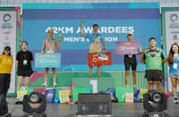 EDSEL Moral (middle) lifts the trophy after ruling the men’s 42km event of the Sante Barley Trilogy Run Asia National Finals on Saturday at the Mall of Asia Complex.