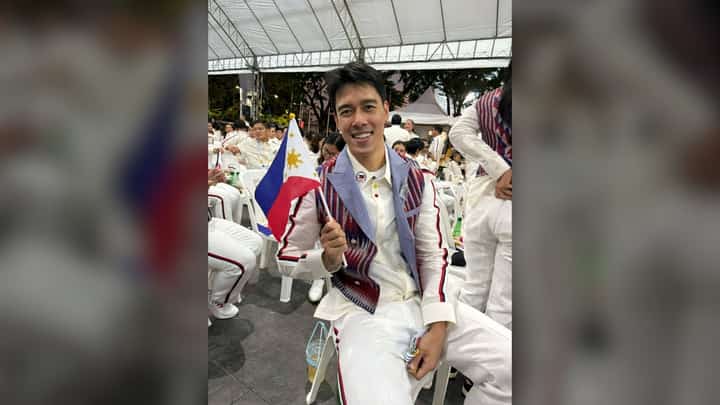 BRYAN Bagunas is honored to carry the national flag during the parade of nations of the 33rd Southeast Asian Games on Tuesday evening at the Rajamangala Stadium in Bangkok.