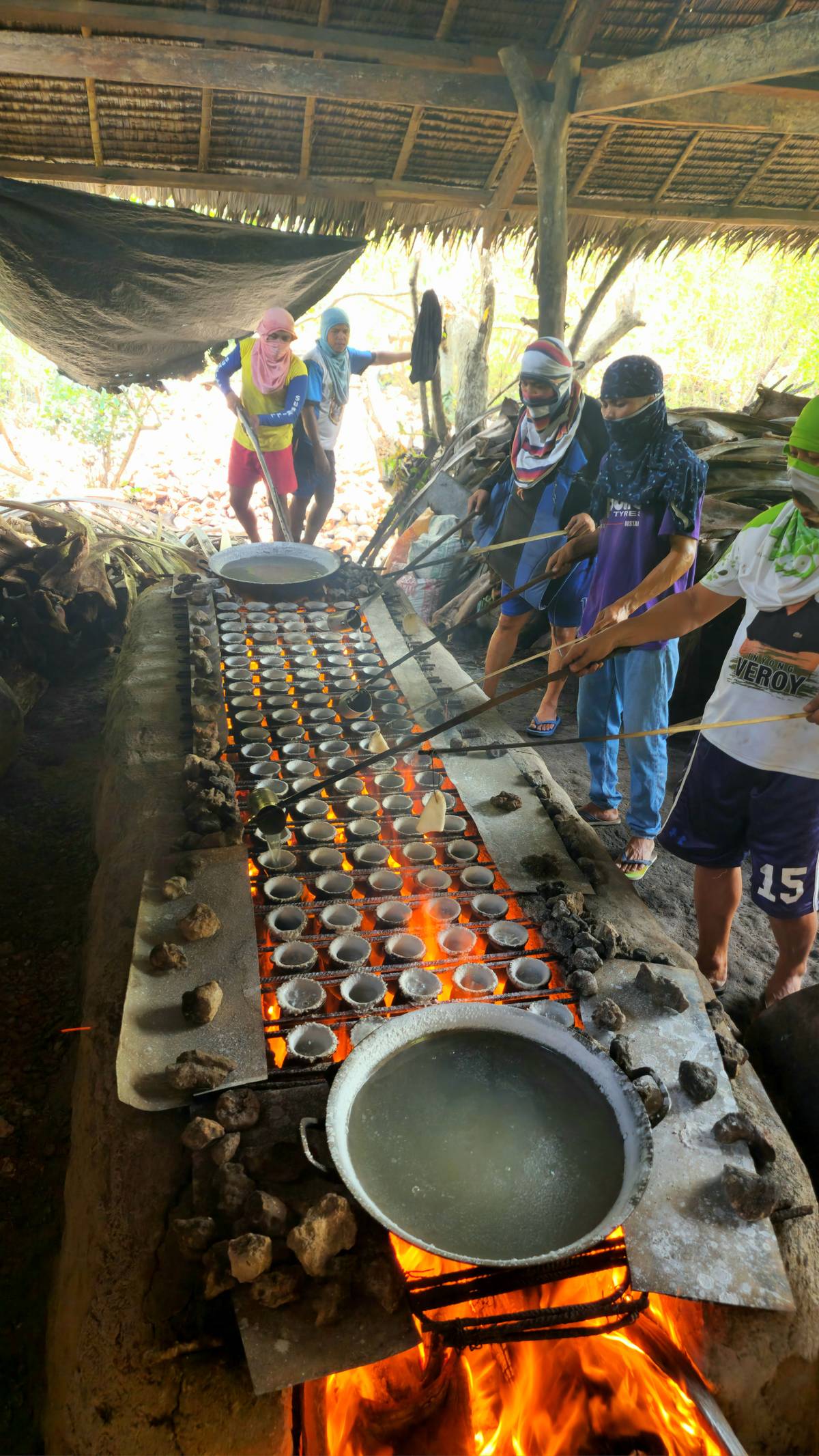WORKERS cook the brine at the oven to make salt.