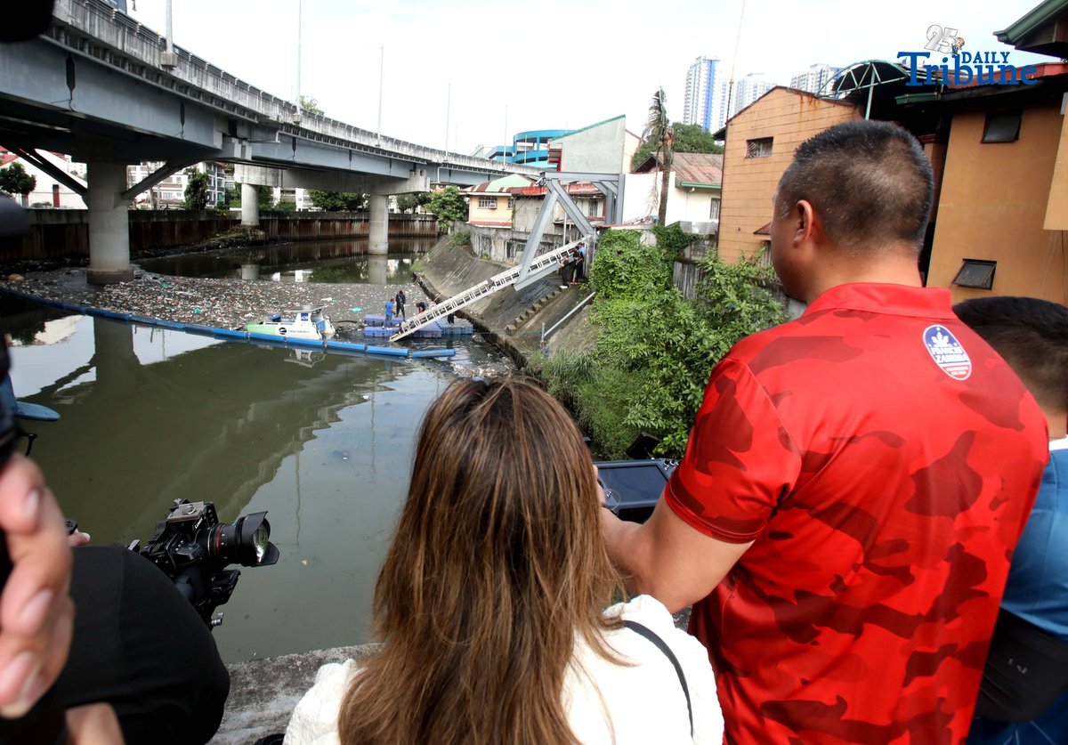 (December 11 2025) San Juan City Mayor Francis Zamora joins the Asian Development Bank’s country representative in demonstrating the ADB–MMDA ClearBot Project during its launch on Thursday, 11 December 2025.
The ClearBot, a solar-powered, AI-enabled robotic vessel designed to remove floating garbage from waterways, was deployed along the San Juan River near the N. Domingo Bridge to help address the city’s persistent trash problem. Photo/Analy Labor