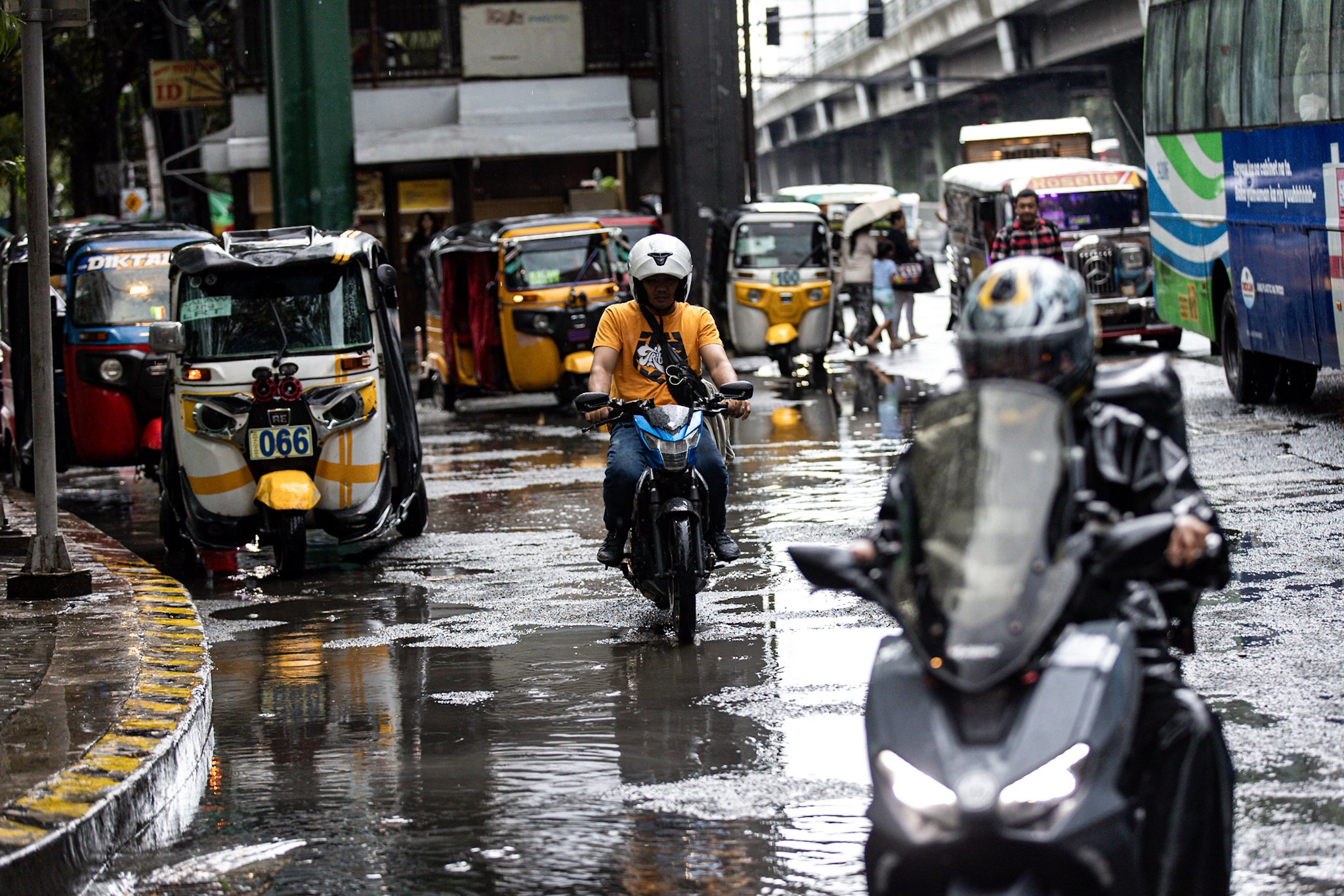 Commuters navigate the streets following a sudden heavy downpour along Taft Avenue in Manila on Tuesday, 16 December 2025. The short but intense rain resulted to some areas being in gutter-deep flood.
