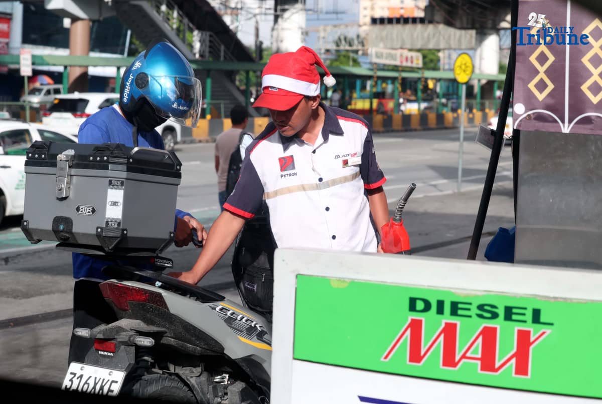 (December 16 2025) A gasoline attendant wearing a Santa Claus hat fills up vehicles of their customer at a gasoline station along EDSA in Cubao, Quezon City on Tuesday, December 16, 2025. Pump prices are set to adjust by oil companies starting Tuesday, with gasoline hike prices by P0.20 per liter, while diesel and kerosene prices will roll back by P0.20 per liter. Photo/Analy Labor