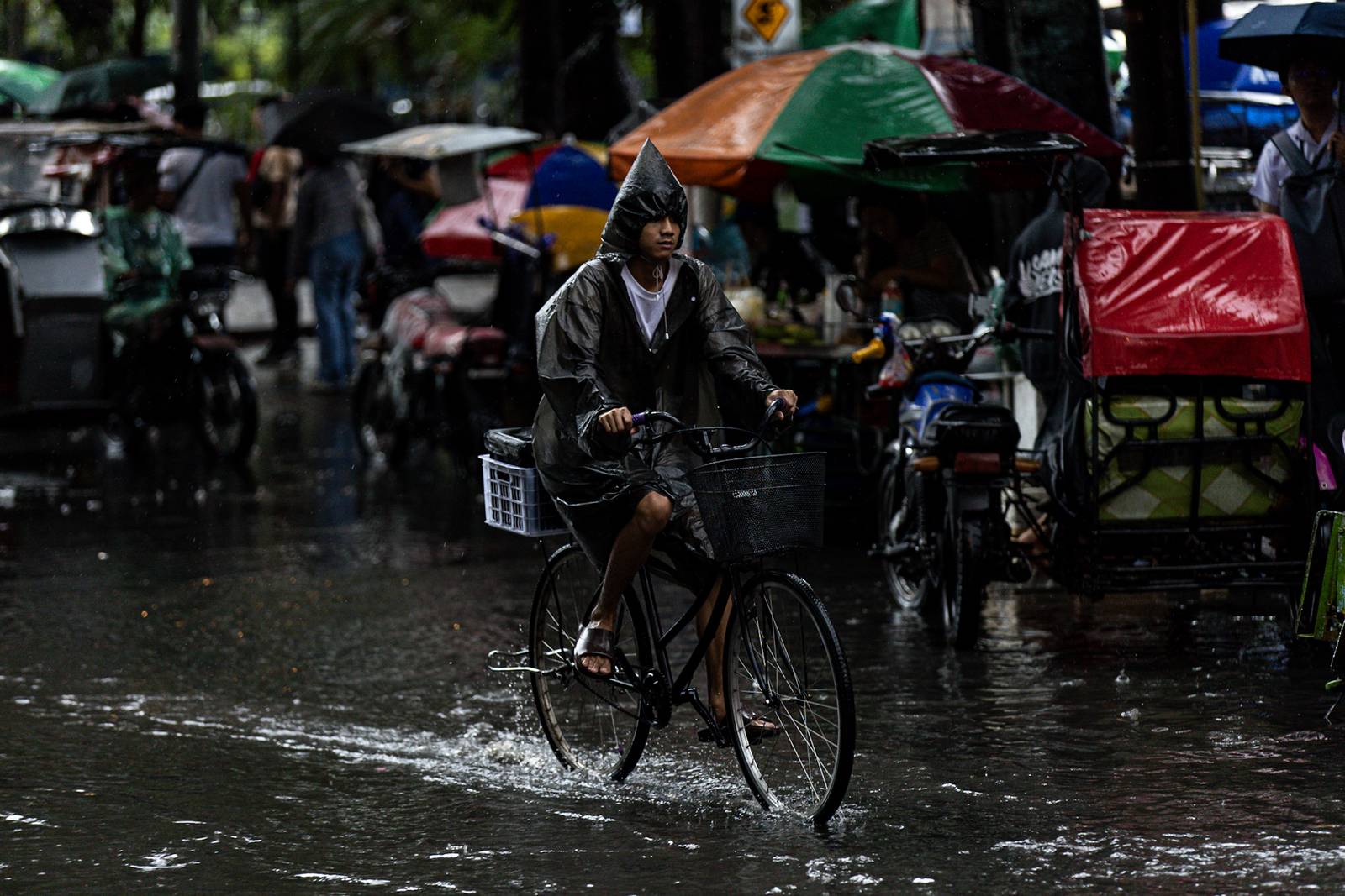 Commuters navigate the streets following a sudden heavy downpour along Taft Avenue in Manila on Tuesday, 16 December 2025. The short but intense rain resulted to some areas being in gutter-deep flood.