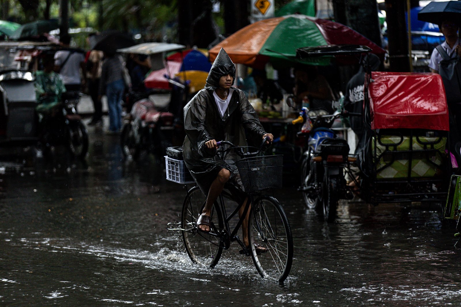 Commuters navigate the streets following a sudden heavy downpour along Taft Avenue in Manila on Tuesday, 16 December 2025. The short but intense rain resulted to some areas being in gutter-deep flood.